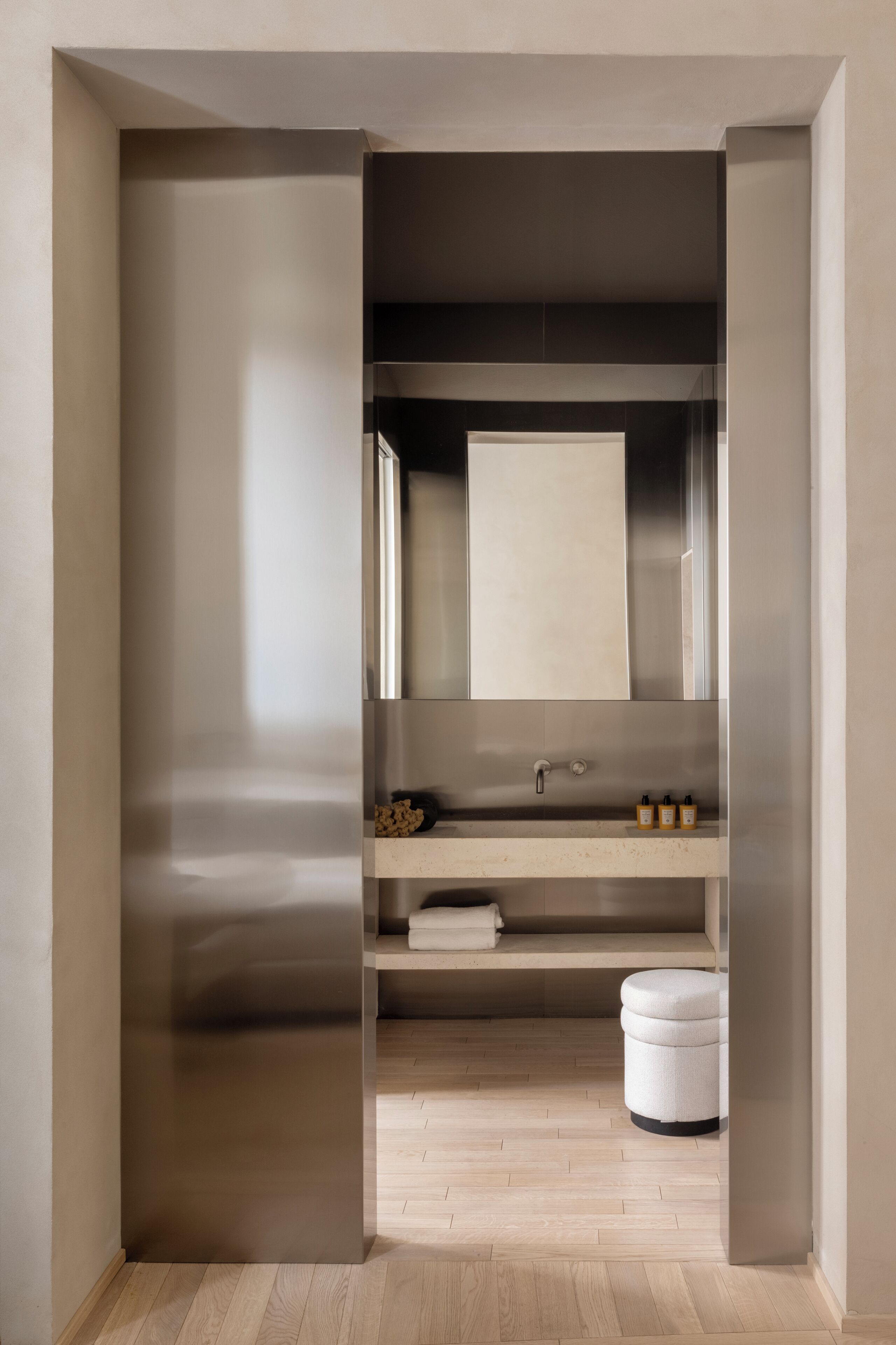 Un baño moderno con un espejo grande, un lavamanos y un inodoro.