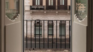 A building with multiple windows and balconies, viewed through a glass door. - Hotel Trame (Rome)