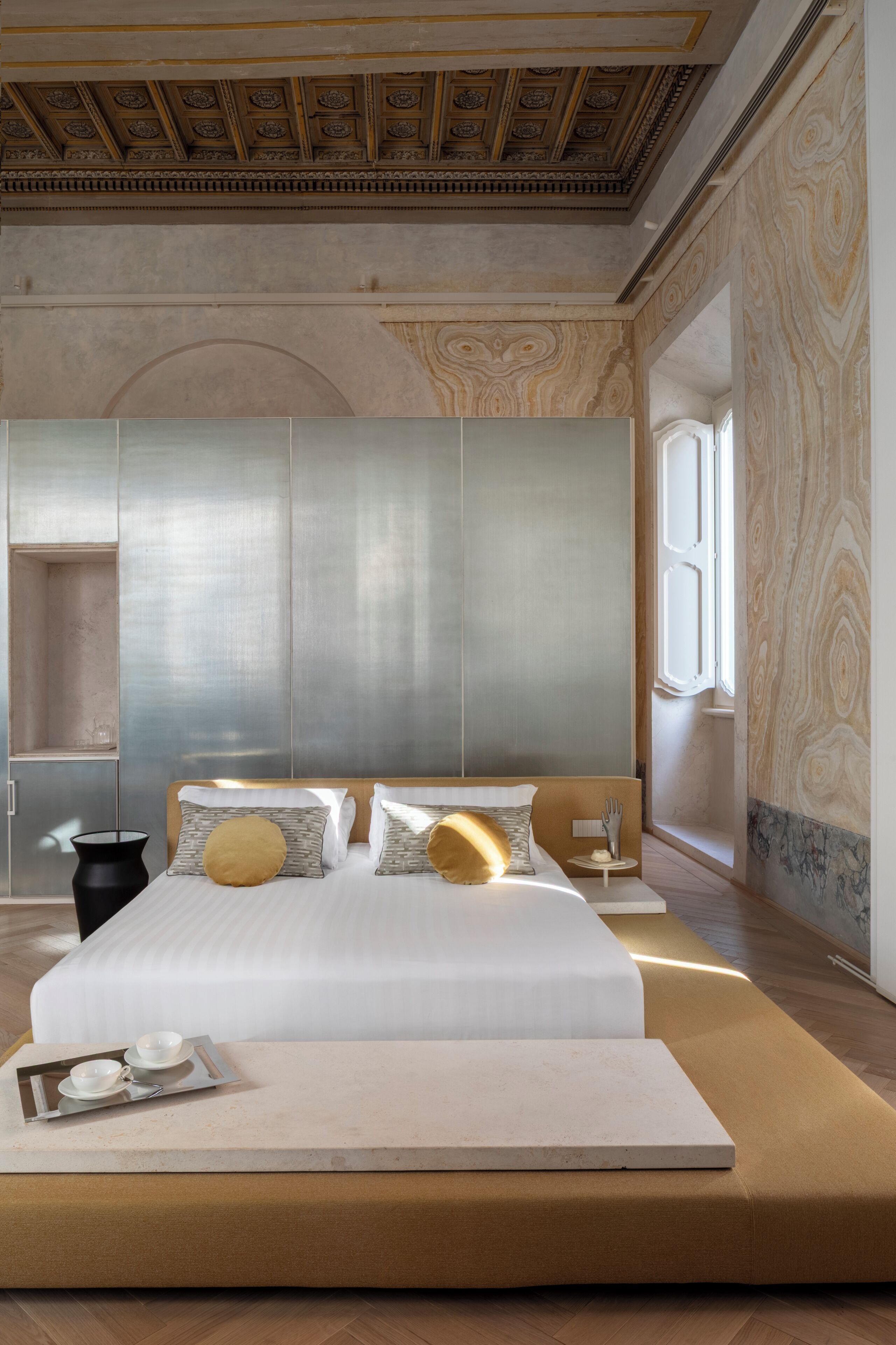 Un dormitorio moderno con una cama grande, una mesita de noche y una ventana.