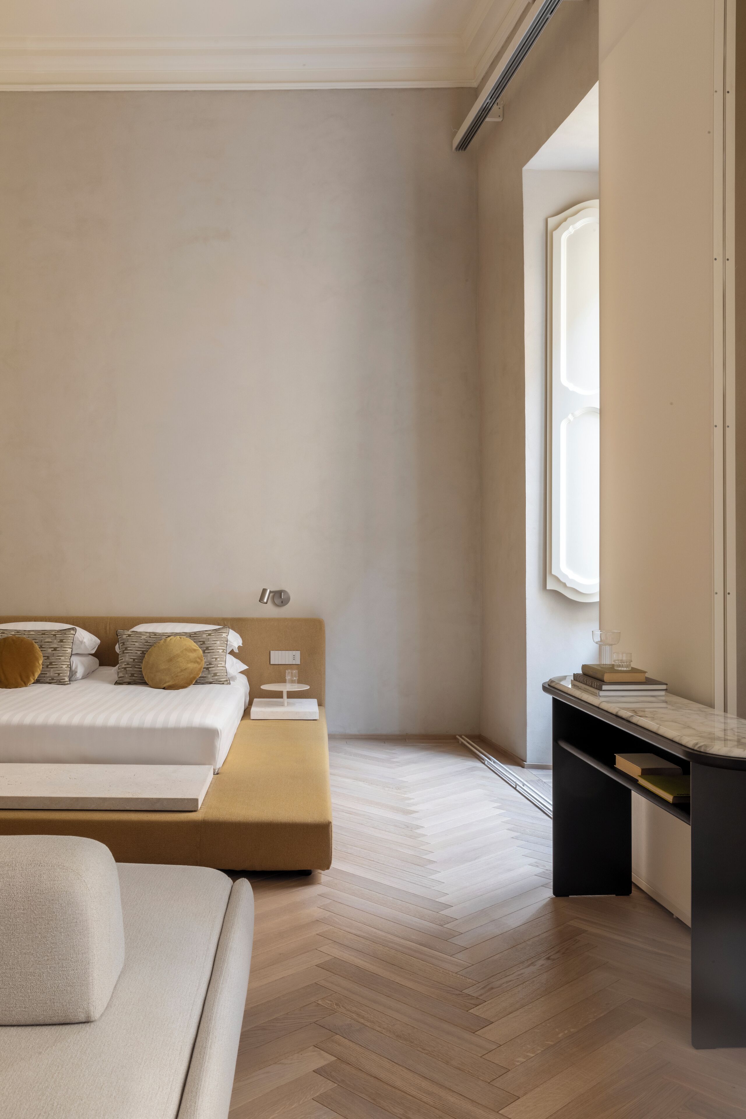 A modern bedroom with a bed, bedside table, and a desk.