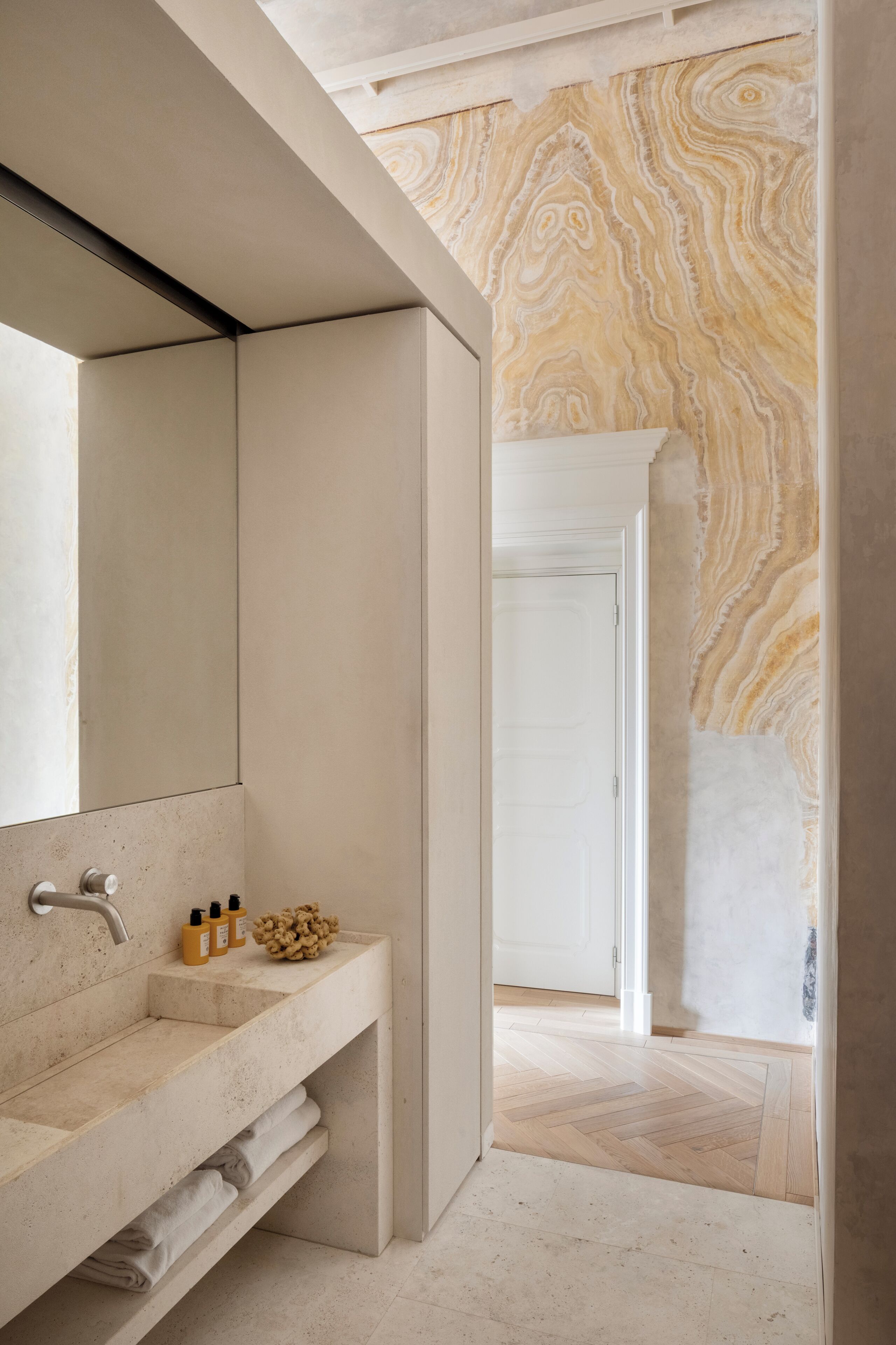 A modern bathroom with a large mirror, a sink with a countertop, and a shower area.
