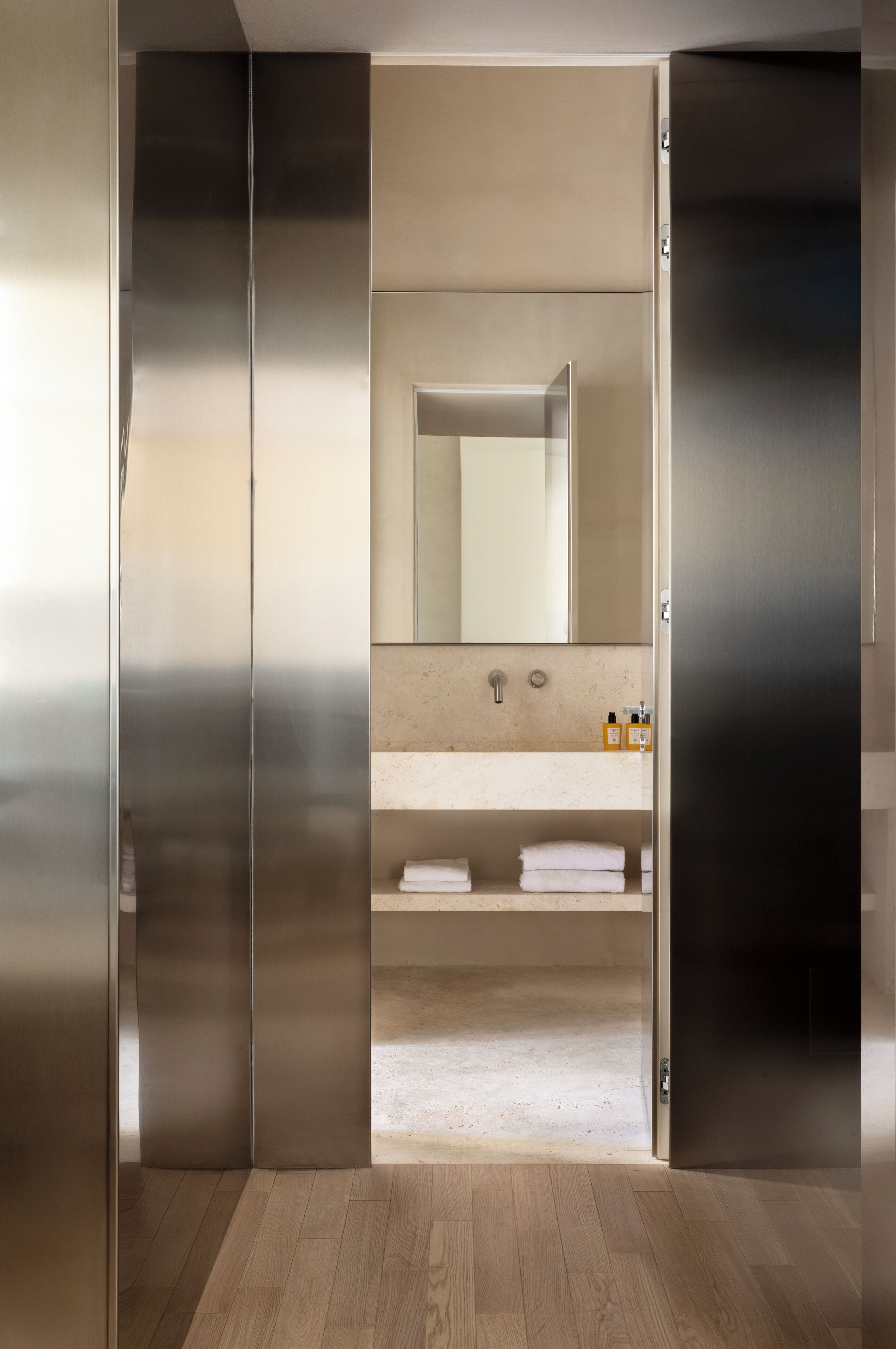 A modern bathroom with a large mirror, a sink, and a towel rack.