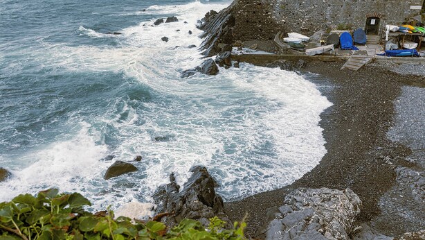 A rocky shoreline with waves crashing onto the beach. - Quinto Modern Flat by Wonderful Italy (Genoa)