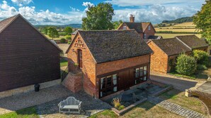 A traditional brick house with a sloped roof, a small porch, and a gravel driveway. - Poplar Cottage | Sleeps 3 | Near Broadway (Dumbleton)