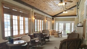 A spacious room with wicker furniture, large windows, and a ceiling fan. - Crafts Inn, Hotel Suite with pool and hot tub. (Wilmington)