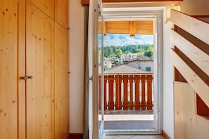 A wooden interior with a view of a balcony and buildings outside.