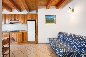 A kitchen with wooden cabinets, a refrigerator, and a dining table with chairs.
