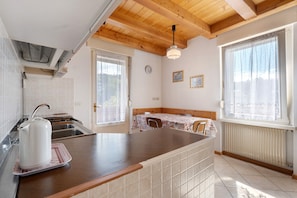 A kitchen with a kettle, a sink, and a window with a view.