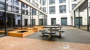 A courtyard with outdoor seating areas and a brick floor. - Student Only Market Quarter (Bristol)