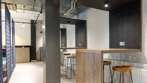 A modern kitchen with a central island, bar stools, and a large mirror. - Student Only Market Quarter (Bristol)
