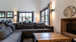 Un salon moderne avec un canapé d’angle, une table basse en bois et une cheminée.