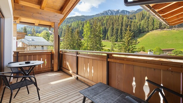 A wooden deck with a table and chairs, overlooking a mountainous landscape. - Apartment 'Weissbrunn Alexander' with Mountain View, Shared Terrace and Wi-Fi (St. Maddalena)