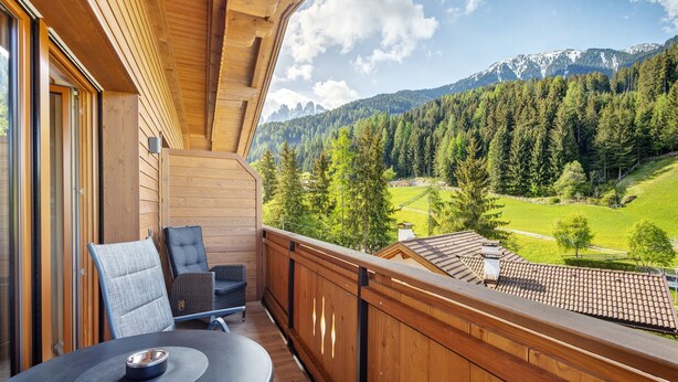 A wooden balcony with a table and chairs, overlooking a mountainous landscape. - Apartment 'Weissbrunn Dominik' with Mountain View, Shared Terrace and Wi-Fi (St. Maddalena)
