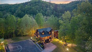A lodge with a basketball court, surrounded by dense forest. - Rivers Edge Luxury Sevierville Cabin - Sleeps 18 (Sevierville)
