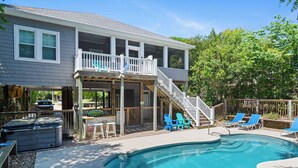 A residential pool area with a covered deck, outdoor seating, and a staircase leading to an upper level. - 4 BR Cottage w/ Pool, Hot Tub, Tiki Bar, 2 King Suites - Walk to Beach (Emerald Isle)