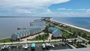 A coastal hotel with multiple buildings, a marina, and a beach.