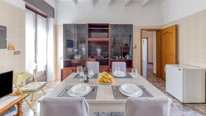 A dining area with a table set for four, a television, and a refrigerator. - Villetta Municipio - Salento Apartment with Private Terrace, Wi-Fi & Air Conditioning (Castrignano del Capo)