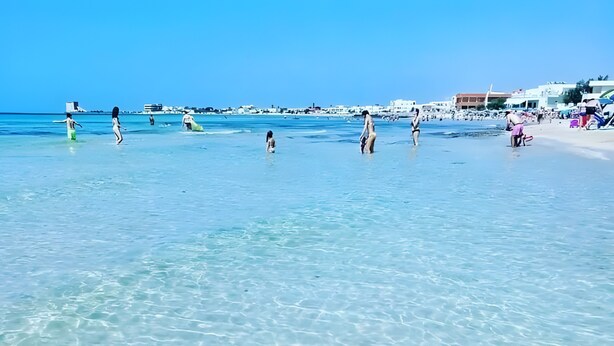A beach with clear water and people in the distance. - Villetta Municipio - Salento Apartment with Private Terrace, Wi-Fi & Air Conditioning (Castrignano del Capo)