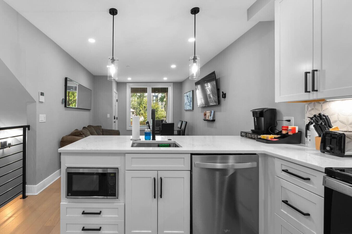 Cozinha moderna com ilha central, eletrodomésticos de aço inoxidável e iluminação pendente.
