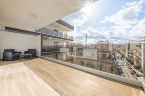 Un appartement moderne doté d’un balcon, offrant une vue sur la ville et comprenant un coin repas.