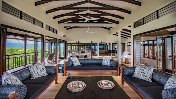 A spacious living area with a high ceiling, large windows, and a central seating area with a sofa and coffee table. - Bangalow - Best View in Port Douglas (Port Douglas)