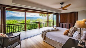 A bedroom with a large window, a bed, a chair, and a nightstand. - Bangalow - Best View in Port Douglas (Port Douglas)