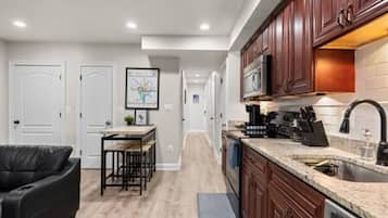 A modern kitchen with wooden cabinets, a built-in oven, and a stainless steel sink.