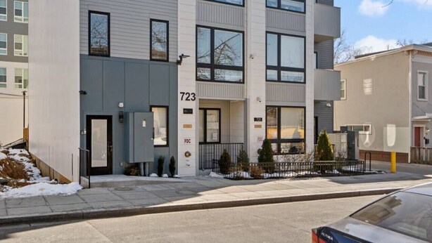 Un immeuble résidentiel à plusieurs étages, doté d’un design moderne, de grandes fenêtres et de balcons.