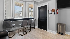Une pièce moderne avec une porte noire, un extincteur et une poubelle.
