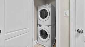 A laundry room with two stacked front-loading washing machines.