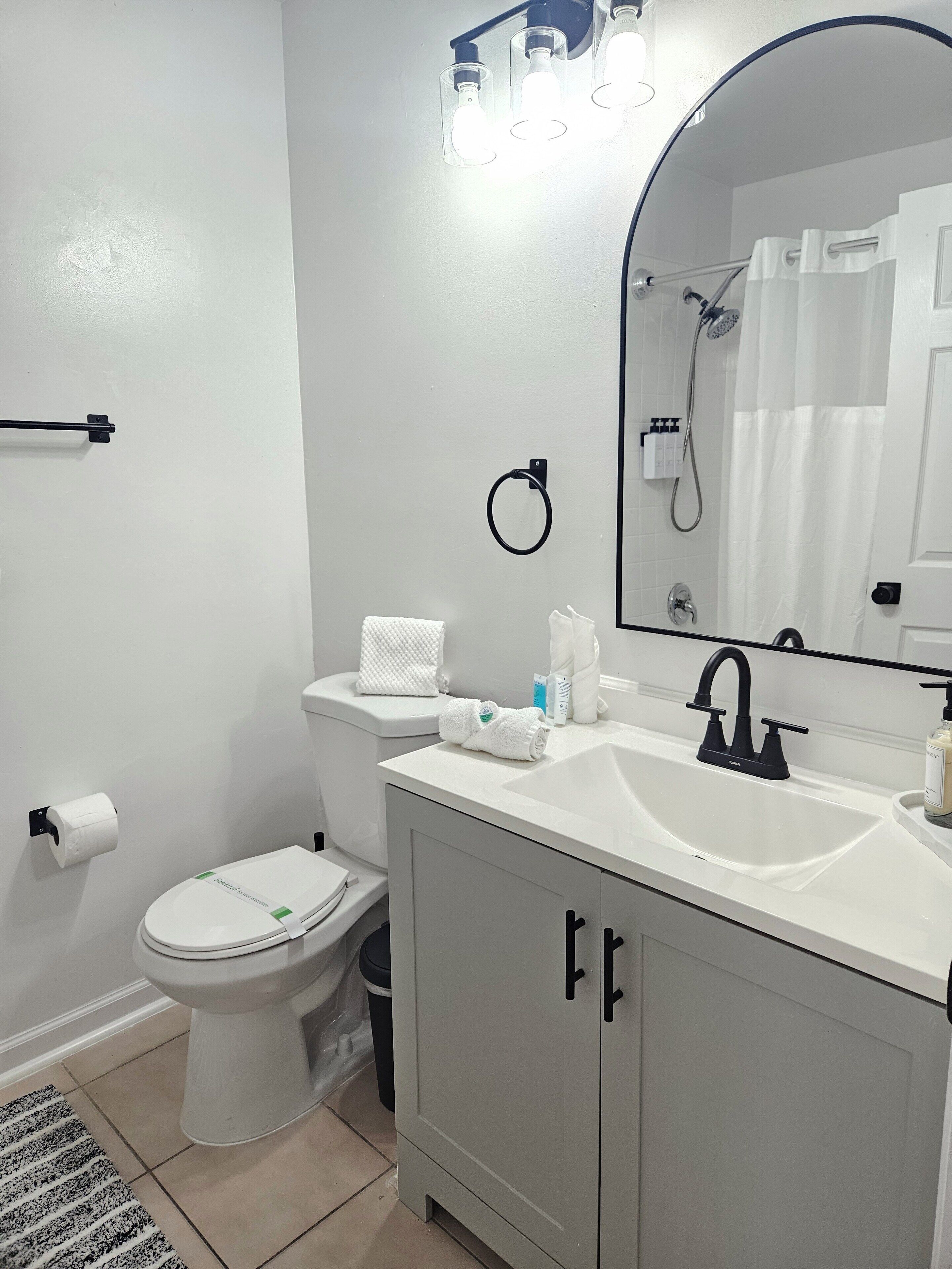 Une salle de bain avec des toilettes, un lavabo et un miroir.