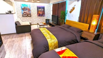 A hotel room with a large bed, a desk, a chair, a TV, and a plant.