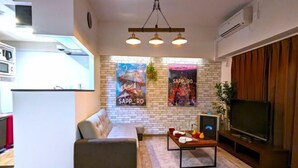 A modern living room with a sofa, a coffee table, a TV, and a fireplace. - KIYAZA Station Sapporo 2 (Sapporo)