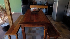 A kitchen with a wooden table, a built-in oven, and a refrigerator. - Casa com Piscina e Churrasqueira no Pantanal (Angra dos Reis)