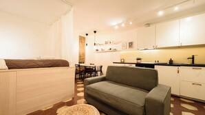 A compact living space with a sofa, a dining area, and a kitchenette. - Vico Santa Luciella 20 (Naples)