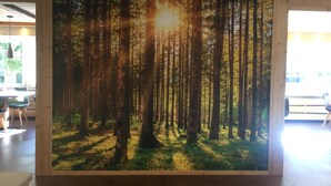 A large forest mural in a spacious room with a modern design, a dining area, and a view of the outside. - Room 'Fedaia Joy Bnb Suite' with Mountain View, Balcony and Wi-Fi (Canazei)