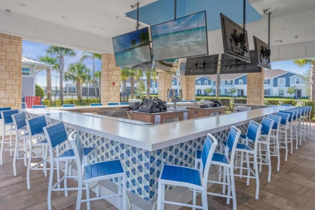 A spacious outdoor bar area with a long counter and multiple seating options.