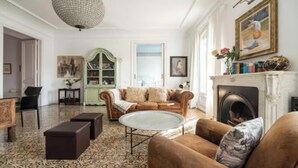 Ein Wohnzimmer mit braunem Sofa, einem runden Couchtisch und einem Kamin.
