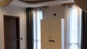 A room with a wardrobe, a door, and a window with curtains. - B&B linate (Peschiera Borromeo)