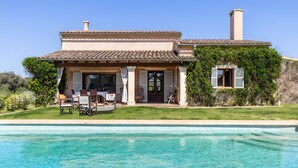 A two-story house with a swimming pool, a patio with outdoor furniture, and a chimney. - Countryside finca in Mallorca with Private Pool, Tradition and Nature (Illes Balears)