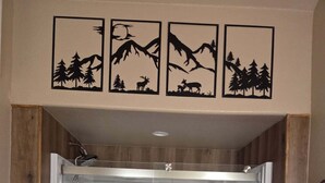 A shower enclosure with a glass door, a wooden wall paneling, and a shelf with towels. - Private cabin for two
National Forest and outdoor fireplace 
Near Hot Springs (Glenwood)