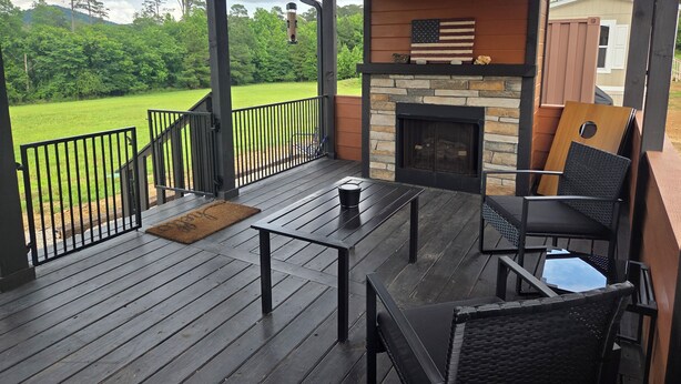 A covered deck with a stone fireplace, outdoor seating, and a view of a green landscape. - Private cabin for two
National Forest and outdoor fireplace 
Near Hot Springs (Glenwood)