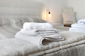 A neatly made bed with folded white towels and a bedside lamp. - Villa Mario Pool and Relax: Private Pool & 6,000 m² Garden in Puglia (Mottola)