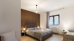 Ein modernes Schlafzimmer mit einem großen Bett, Nachttischen, einem Fenster mit Vorhängen und einer Wand mit Holzverkleidung.