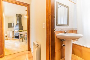A room with a white sink, wooden door frame, and a tiled backsplash. - Charming Pyrenean Flat with Terrace, Views & Pool (Anciles)