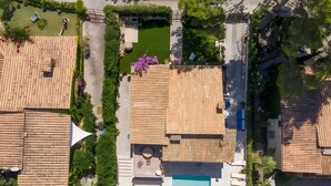 An aerial view of a residential area with multiple houses, a swimming pool, and a garden. - Authentic Mediterranean Villa (Cala Sant Vicenç)