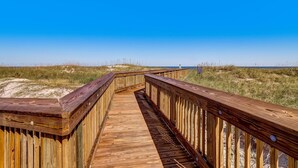 A wooden boardwalk leading to a beach with dunes and a clear blue sky. - Amelia Island 2BR Beach Getaway (Fernandina Beach)