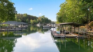 A calm lake with docks and covered structures, surrounded by trees.