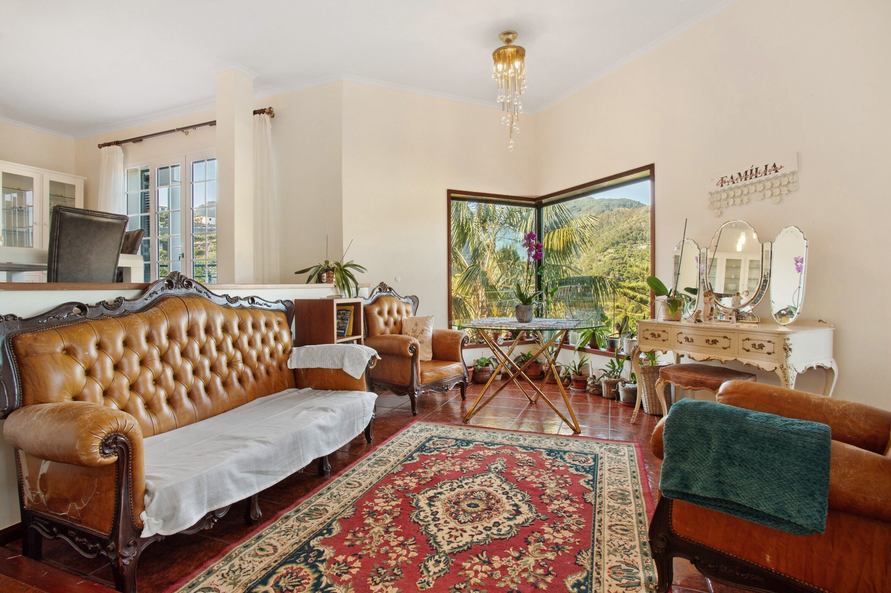 A living room with a sofa, armchair, and a small table with a mirror.
