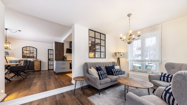 A modern living room with a sofa, armchairs, a coffee table, and a dining area with a table and chairs. - Apartment 'Jost' with Private Terrace, Shared Garden, and Wi-Fi (Sundern)